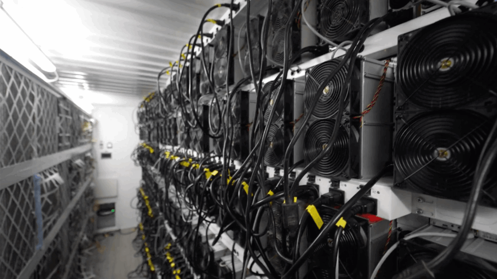 rangées de machines de minage de bitcoin dans un entrepôt ventilé