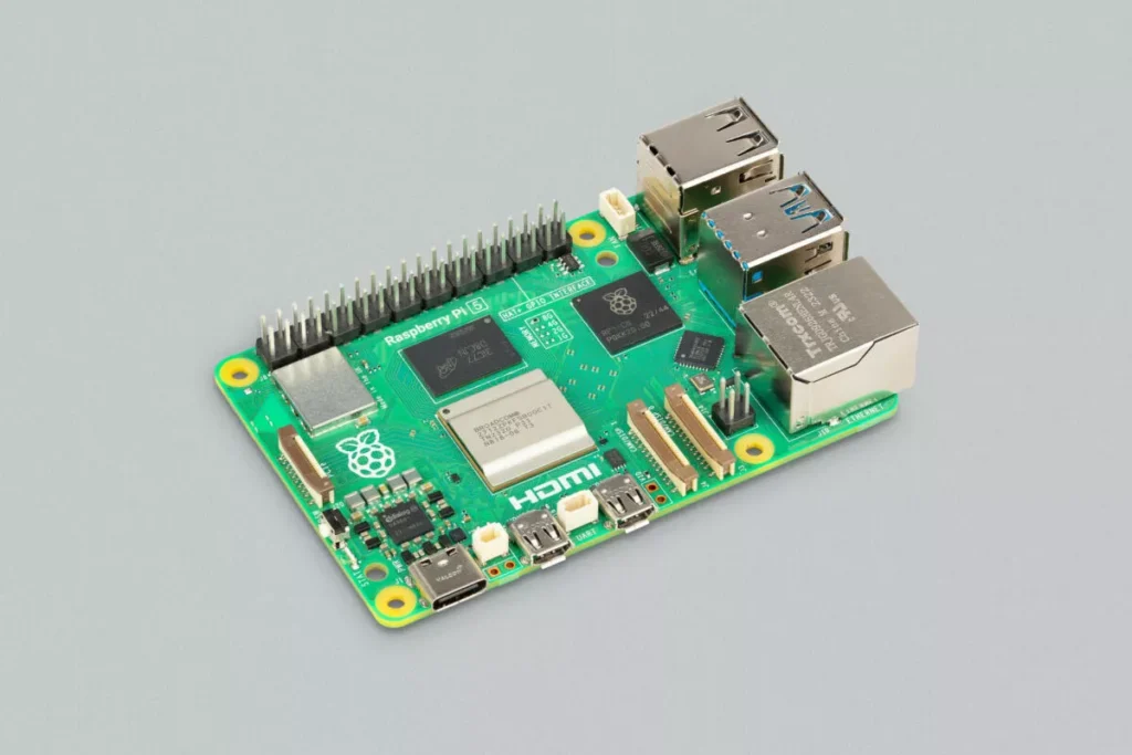 carte Raspberry Pi 5 posée à côté d'une carte bancaire de même dimension Légende : La carte n'a pas grossi depuis 2012. C'est à peu près la seule chose qui n'a pas changé.
