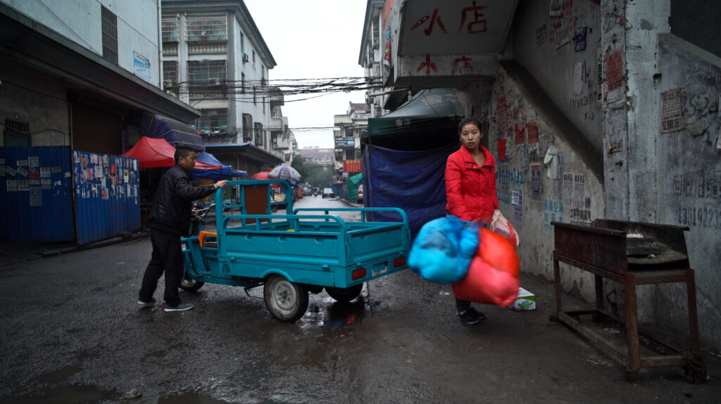 Ruelle de Zhili sous la pluie, ouvrière portant des ballots de vêtements, Jeunesse (Les Tourments)