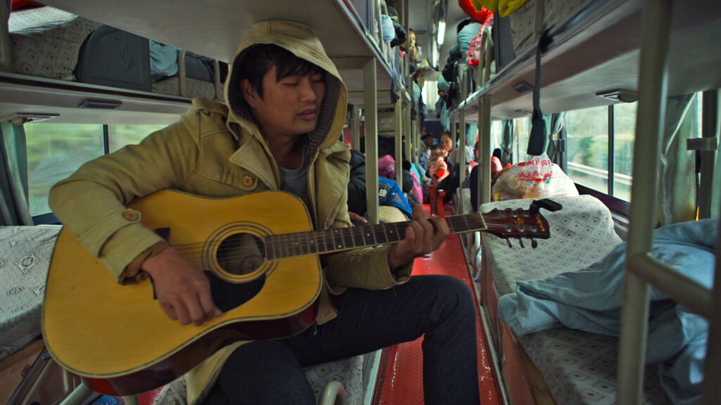 Liu Gang joue de la guitare dans un bus-couchettes vers le Yunnan, Jeunesse (Les Tourments)